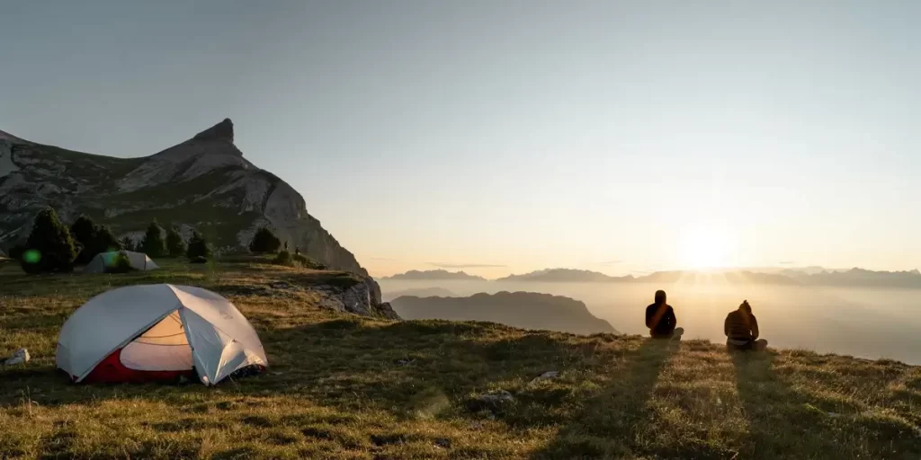 Golden Hour Backpacking Adventure: Two Hikers and Ultralight Tent in Scenic Mountain Landscape