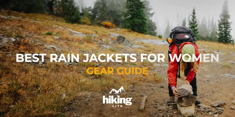 Best Rain Jackets for Women: A hiker on the trail, building a rock statue in wet conditions