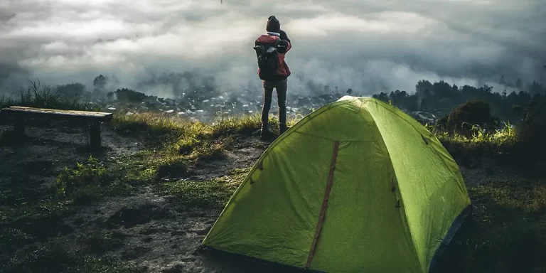 Single-Wall vs. Double-Wall Tents: Hiker at a camp, well-prepared with a double-wall tent for the harsh conditions
