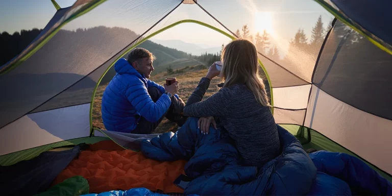 4-Season Sleeping Bag: Campers in a tent during a cold morning with their 4-season sleeping bags