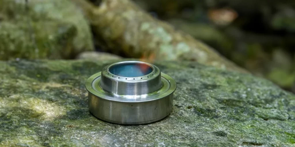 Alcohol Stoves: A close-up of a burning alcohol stove on a rock