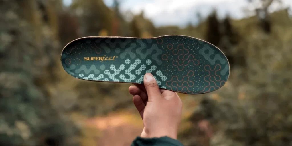 Hiking Insoles: Close-up of a person holding up an ultralight Superfeet hiking insole
