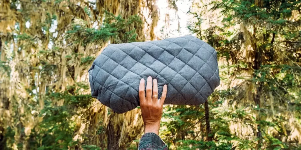 A close-up of a hiker holding a comfy camping pillow