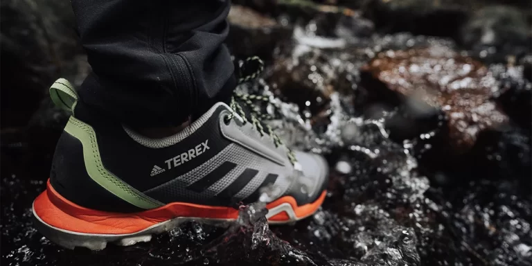 Hiking Footwear: A close-up of trail runners in a water stream
