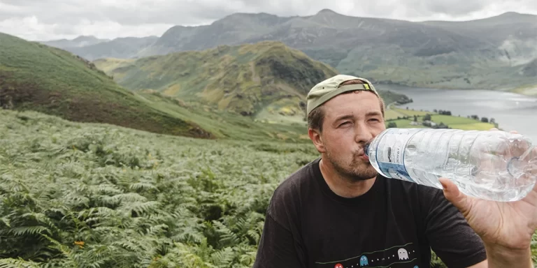 Purification Tablets: Hiker drinking clean water purified with purification tablets.