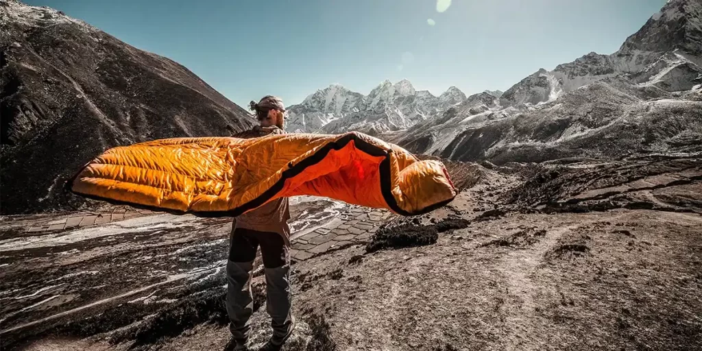 Sleeping Bag Care: A hiker holding his sleeping bag to air it out