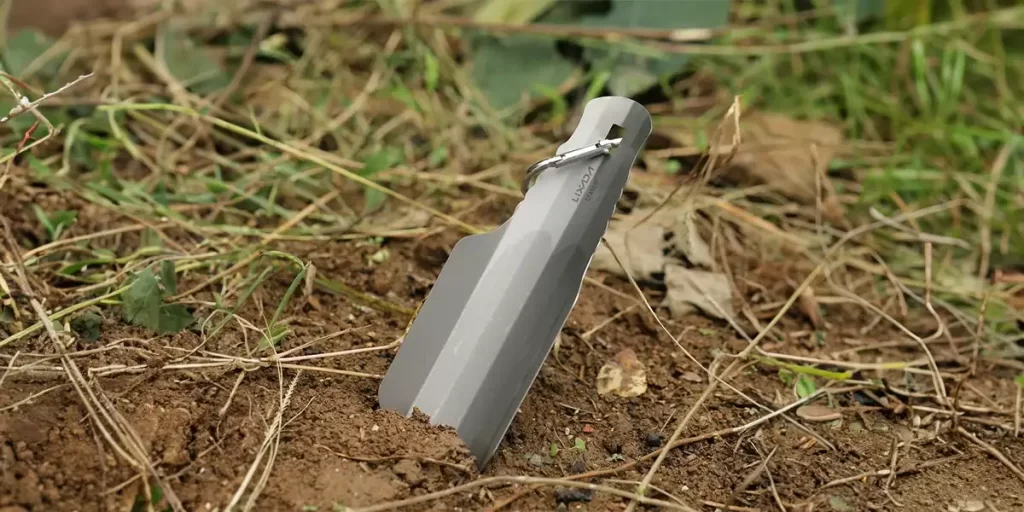 Close-up of an ultralight camping trowel in the ground