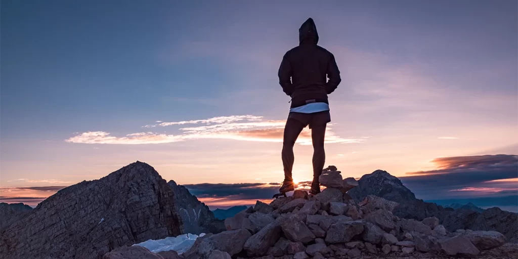 Base Layer Pants: A hiker during sunset wearing base layer pants on a set of rocks