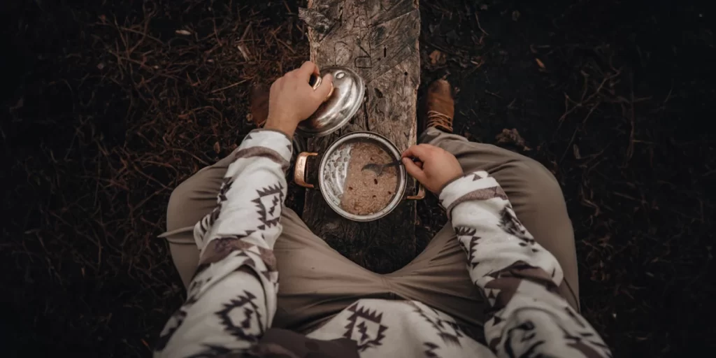 Camping Utensils: A close-up of a camper stirring their breakfast meal with a spoon