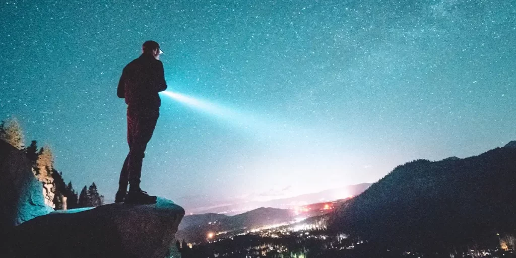 Hiking Lights: A hiker shining their flashlight towards a valley