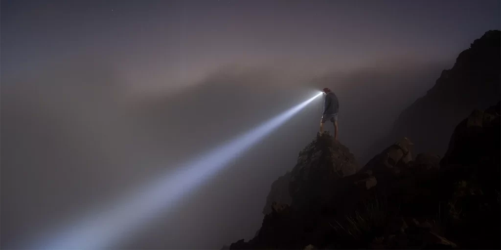 Hiking Lights: A hiker shines their headlamp into the abyss
