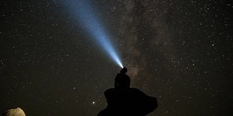 Flashlight vs Headlamp: Hiker with a headlamp staring at the star-filled sky