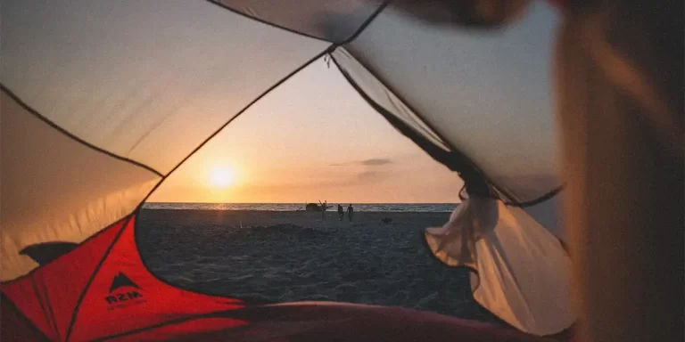 Tent Stakes: A view from inside a tent with a beach backdrop during sunset