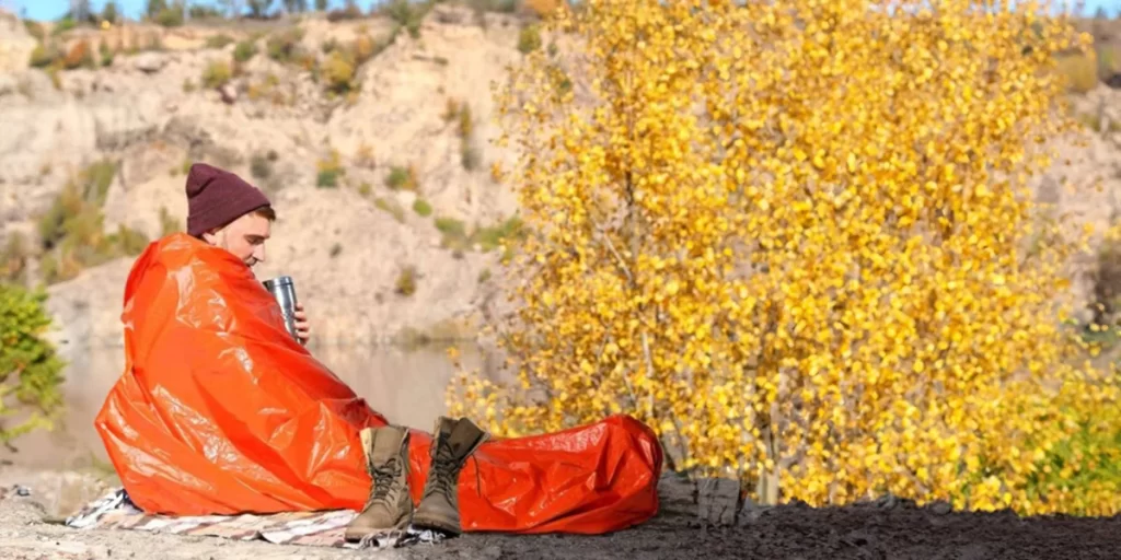Survival Blanket: A hiker on a sunny morning wrapped in a survival blanket