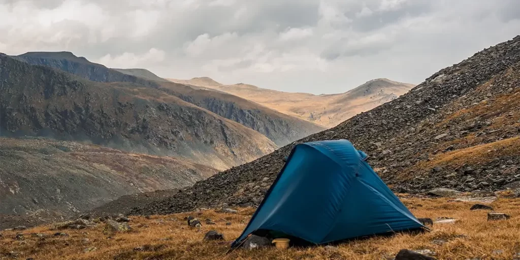 1-Person Tent vs. Bivy Sack: An ultralight 1-person tent pitched in a mountain range