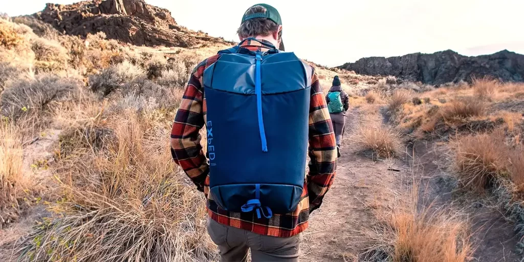 Waterproof Hiking Backpacks: Hiker on a hilly trail with a waterproof Exped backpack