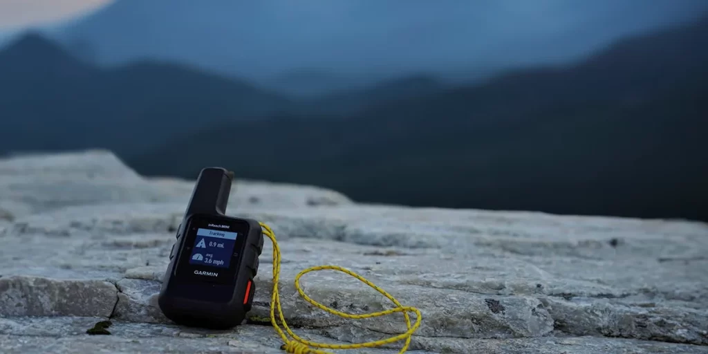Satellite Messengers Explained: A Garmin inReach Mini device on a ledge in the mountains