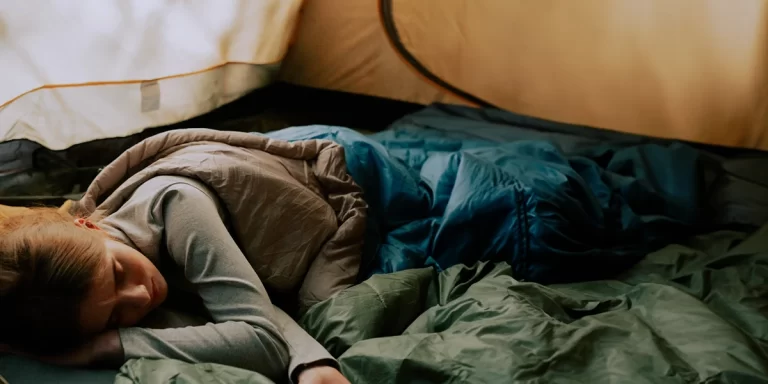 Side Sleeper Camping Tips: A camper sleeping on her side in a suitable sleeping bag