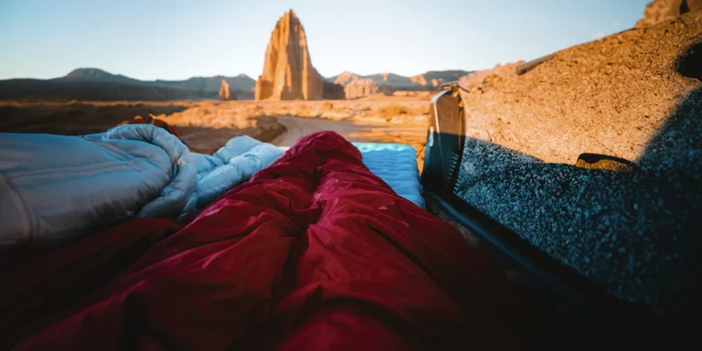 Sleeping Pads: Close-up of a camper in a desert enjoying a cozy morning on their ultralight inflatable sleeping pad