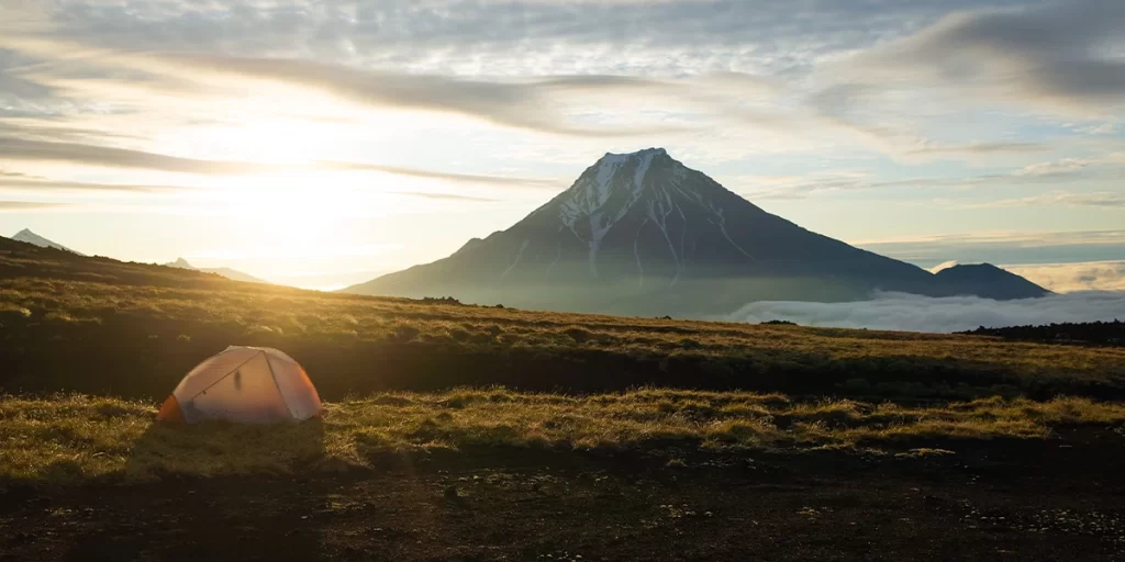 An ultralight 2-person MSR tent set up in a stunning mountain range