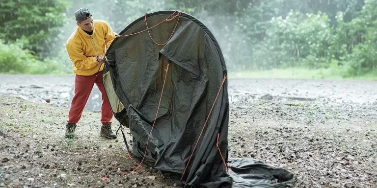 How to set up a tent in the rain: A camper is setting up his tent in the rain