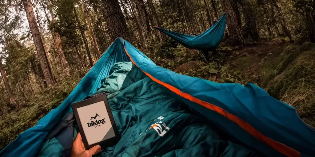 Stealth Camping: A stealth camper in a hammock reading an e-reader