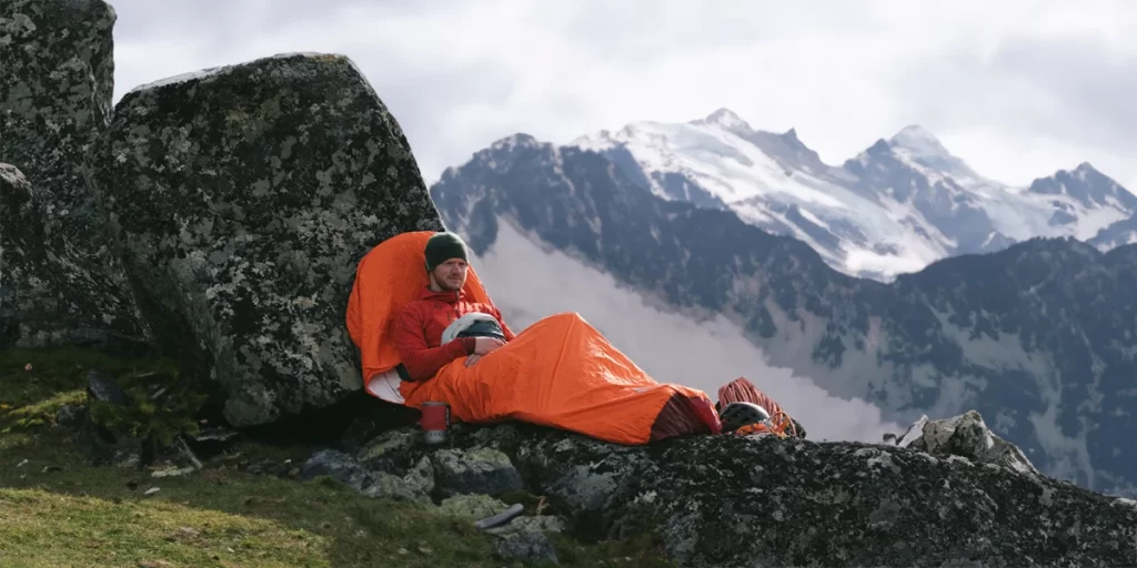 Bivy Sacks: An ultralight backpacker enjoying his morning in his bivy sack in scenic mountains