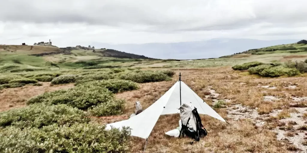 Tarp or Tent: Ultralight Hyperlite tarp on a grassy hill
