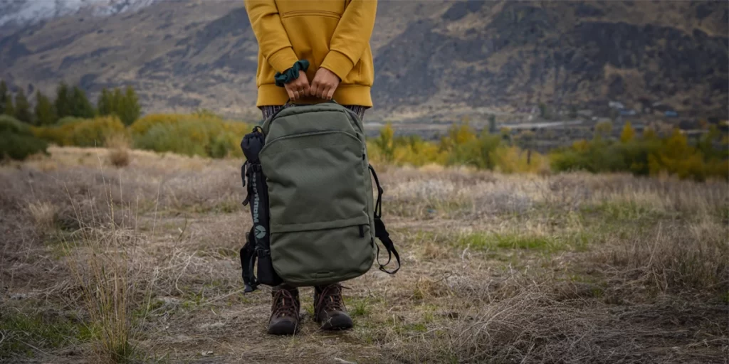How to Clean a Backpack: A hiker standing with a recently washed, clean backpack