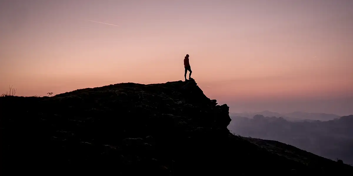 Hiking in Wales: An ultralight backpacker in a national park enjoying a scenic view during sunset