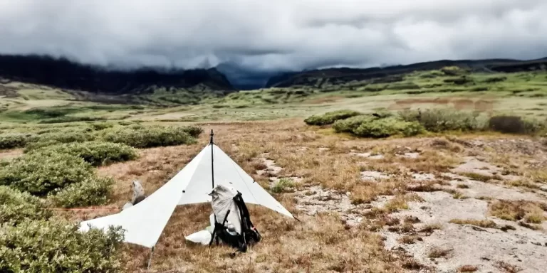 Tarp Camping in the Rain: An ultralight tarp set up in a field, waiting for an upcoming storm