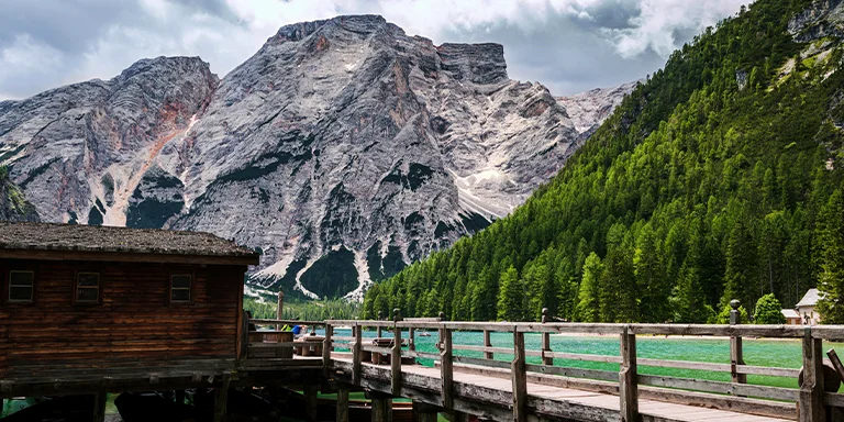 A rustic cabin on the tranquil shores of Lake Braies showcases the idyllic natural beauty of Italy's South Tyrol region