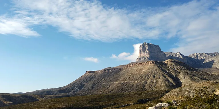 Breathtaking scenic view of the Guadalupe Mountains in Texas, USA on a sunny day, with towering rocky peaks reaching up into a clear blue sky