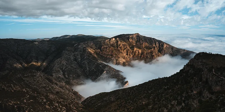 Dramatic aerial view capturing a sea of clouds blanketing the rugged peaks of Guadalupe Mountains National Park at sunrise