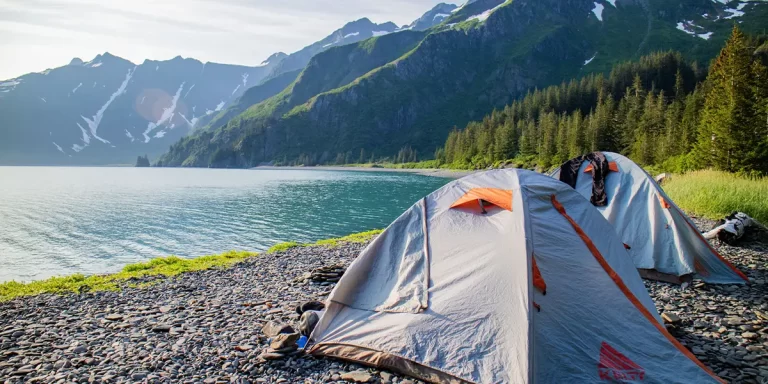 Backpacking in Alaska: Two tents set up at a campsite near a scenic lake