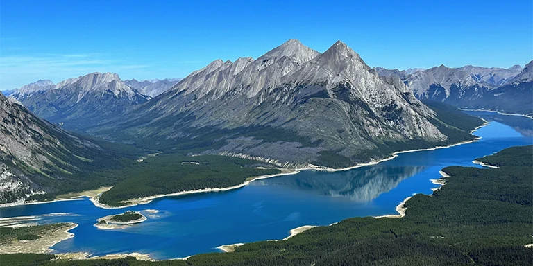 A scenic view of a lake surrounded by mountains in Kananaskis, Alberta, Canada