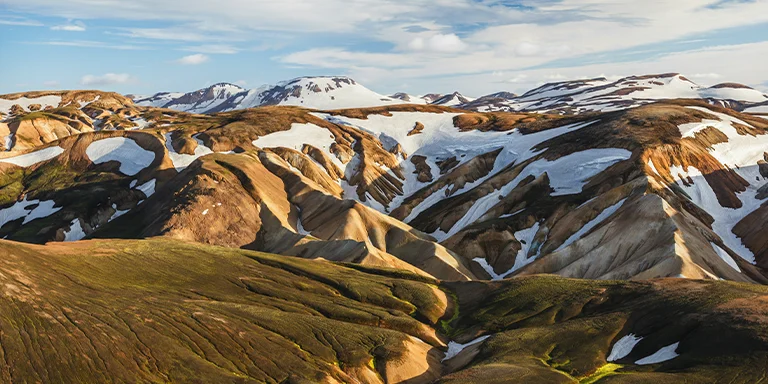 A snow-capped mountain towering over the rocky landscape along Iceland's Laugavegur hiking trail
