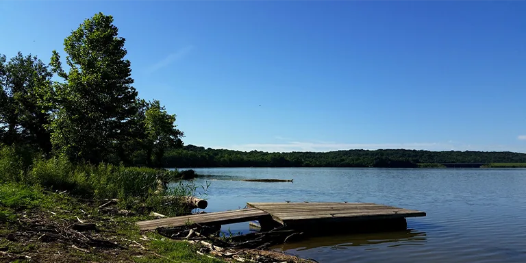 Brookville Lake shimmers under a clear blue sky on a beautiful sunny day, showcasing the natural beauty of the area