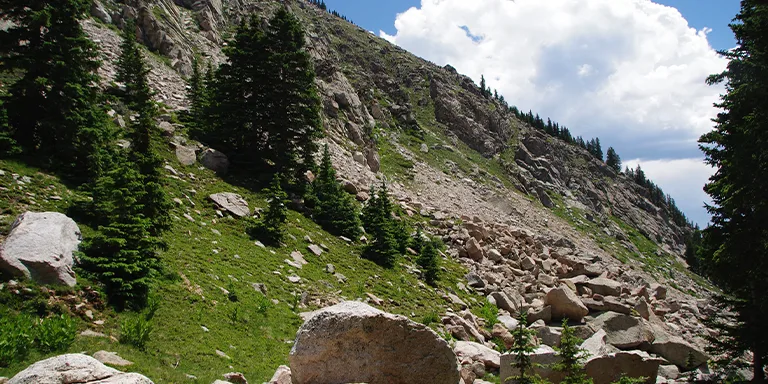 Massive boulders bask in the warm sunlight, scattered across the steep mountainside in the Pecos Wilderness