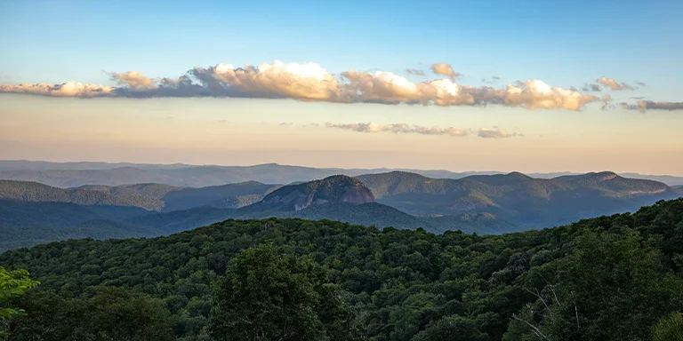 The lush green canopy of ancient forests blankets the sloping Appalachian ridges under a ceiling of wispy white clouds drifting across the endless Carolina blue sky