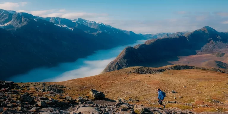 Backpacking in Norway: A hiker on a trail in the Norwegian mountains