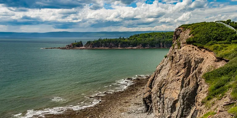 Jutting into the powerful tides of Chignecto Bay, the jagged sea cliffs and exposed reef of Cape Enrage on Barn Marsh Island create a dramatic coastal scene at the entrance to Fundy National Park