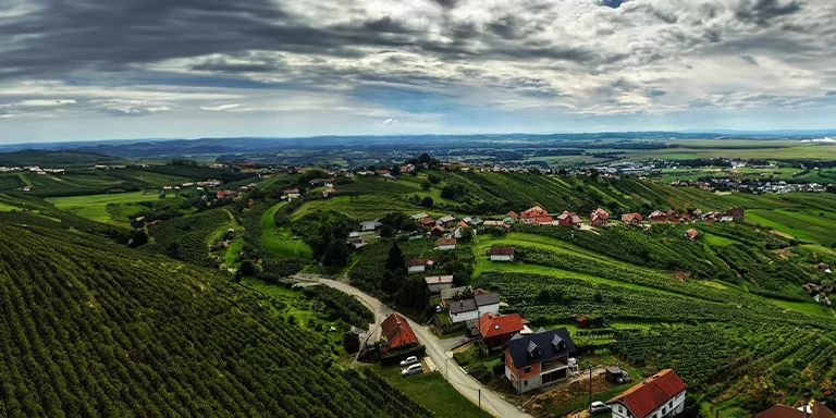 Houses dot a green hillside overlooking the scenic town of Lendava, Slovenia