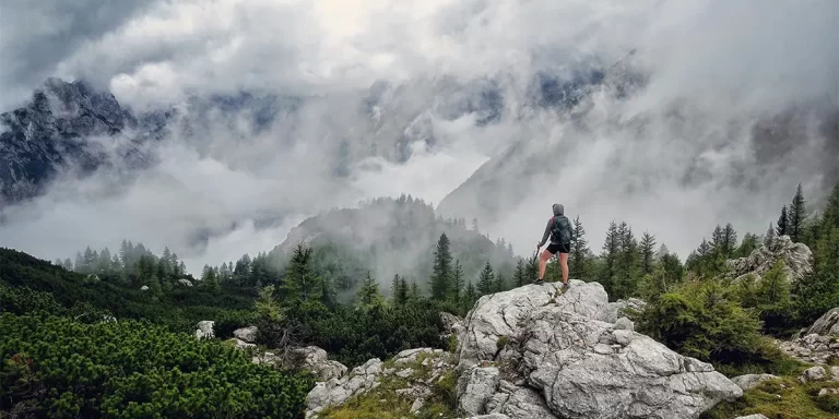 Backpacking in Slovenia: A hiker enjoying a mountain view on a Slovenian trail