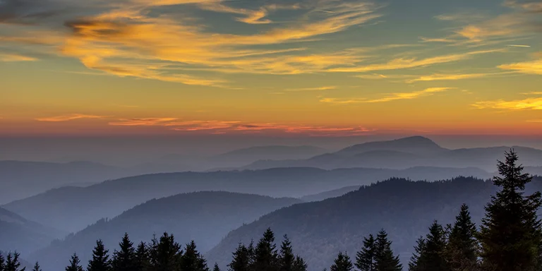 A panoramic view of a sunset over mountainous Feldberg, Germany
